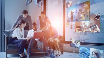 Diverse group of coworkers looking at digital elements on laptop